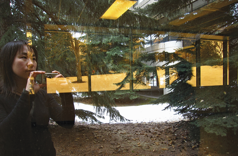 Elsa Lam catches a reflection of herself and the Western Canadian landscape while photographing Craigie Hall at the University of Calgary. Elsa Lam