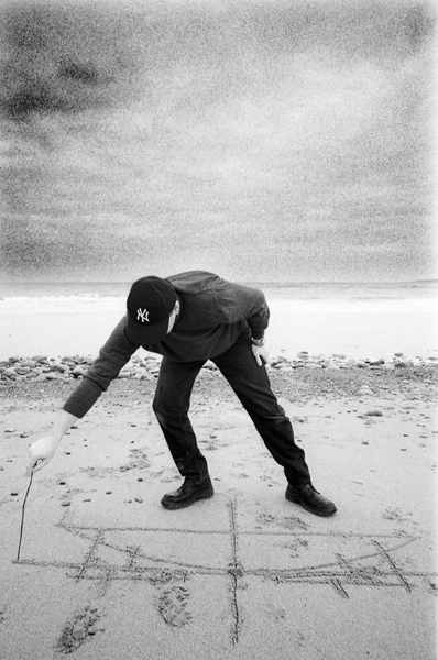 brian mackay-lyons performs a site sketch on the beach