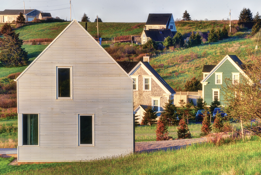 Muir Craig Cottage (2013) comprises a group of minimalist buildings with gabled roofs. Photo by Will Green