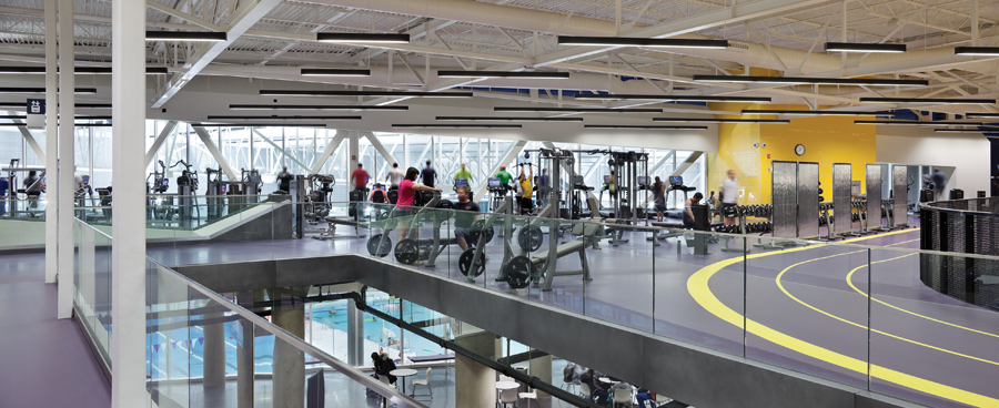 The running track intersects an upper-floor fitness area; the elevated track overlooks a lobby between the gymnasium and natatorium. Photo by Tom Arban