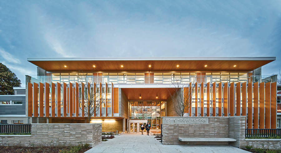Stone walls, planted beds and sheltering overhangs form a deep threshold that welcomes students and teachers to the Senior School.