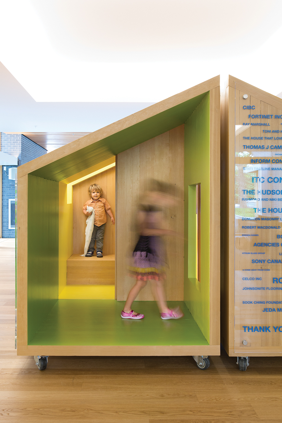 Each grouping of aggregated apartments includes its own kitchen and dining area; play features such as miniature wooden houses and a tube slide that can be used in lieu of the staircase are integrated in the design.