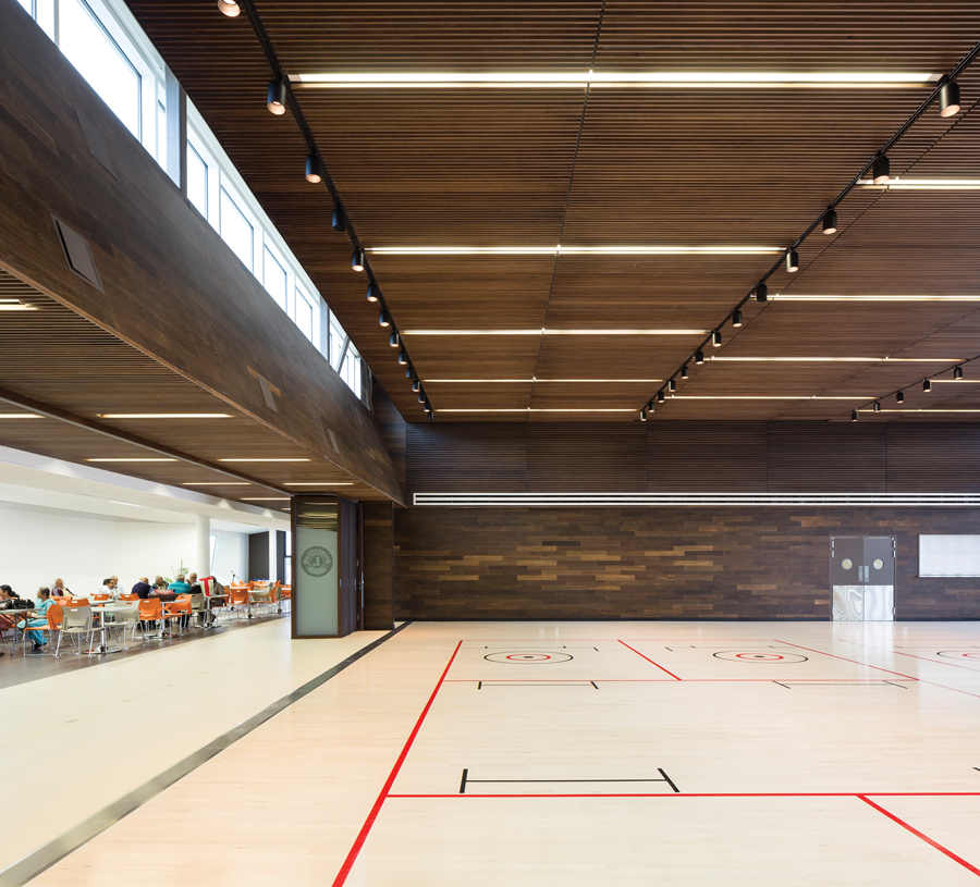 The multipurpose room in the seniors’ centre is clad in rich wood tones.