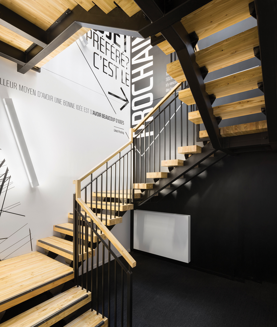 Supergraphics using architectural quotes add zest to the wood-and-steel stairwell of the two-storey structure.