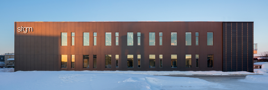 The exterior combines high-performance concrete composite siding, eastern cedar and a solar wall.