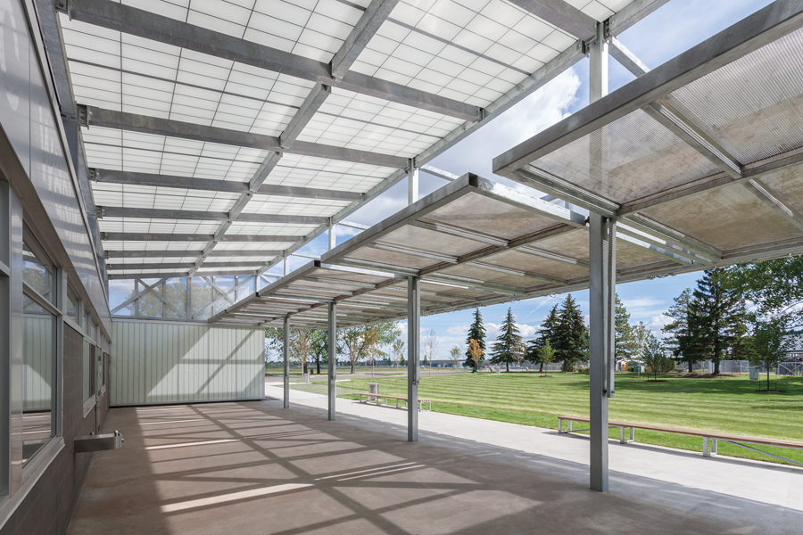 On the long side of the pavilion, full-height panels flip up to create a canopy entrance to a public courtyard with a concession and public washrooms. Photo: Bruce Edward / Yellow Camera