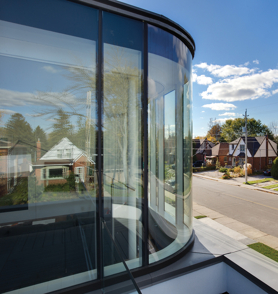 A second-floor addition introduces a subtle curve that wraps around a sun room.