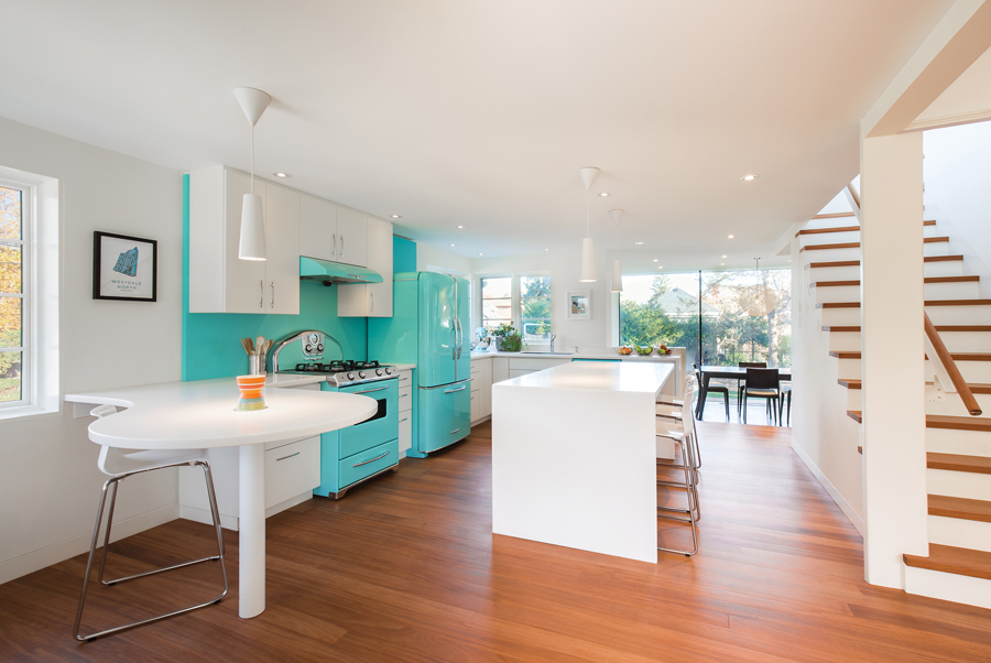 The home’s original partitions were removed to open up the kitchen as the ground floor’s focal point. Retro-inspired appliances from Elmira Stove Works underscore the home’s streamlined aesthetic.