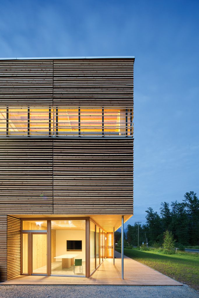 A wood slat screen provides differing degrees of solar shading on the various façades.