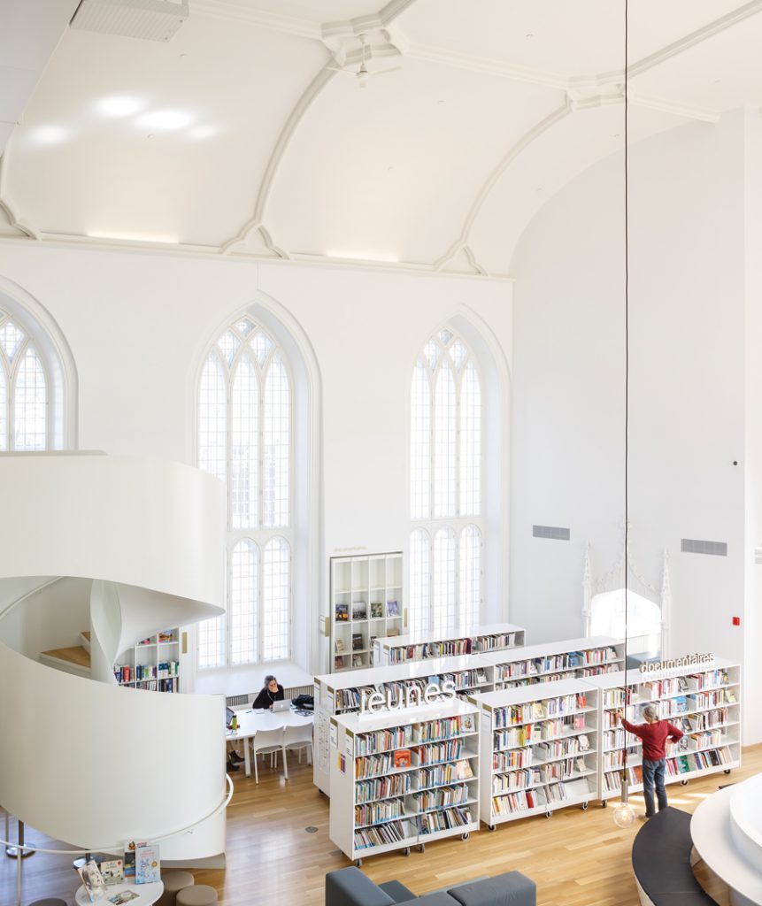 Cathedral windows open onto the open volume of the reading room, which includes a variety of spaces for work and study.