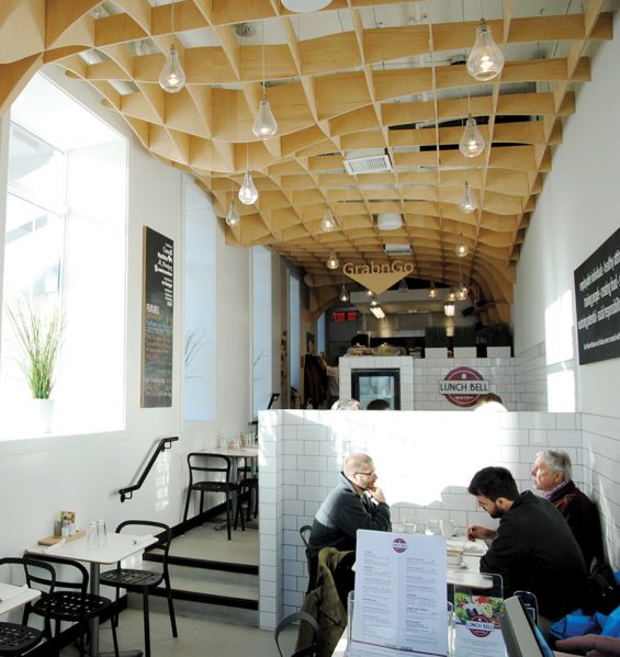 Lunch Bell Bistro is located within Winnipeg’s Bell Hotel, which offers support for recovering addicts; the restaurant is run as a training facility for adults with disabilities. To counter the hard-edged stereotypes of the area, a warm, Baltic birch plywood ceiling casts a comforting blanket over the space. Photo by Michael Butterwoth