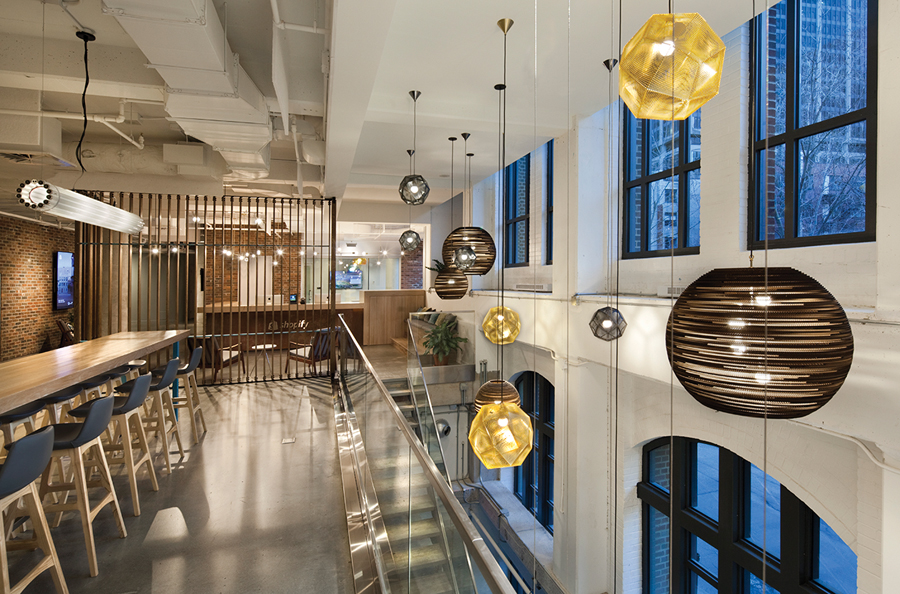 A two-storey atrium at the entrance to the Montreal office showcases the rounded windows of the heritage façade. Photo by Claude-Simon Langlois