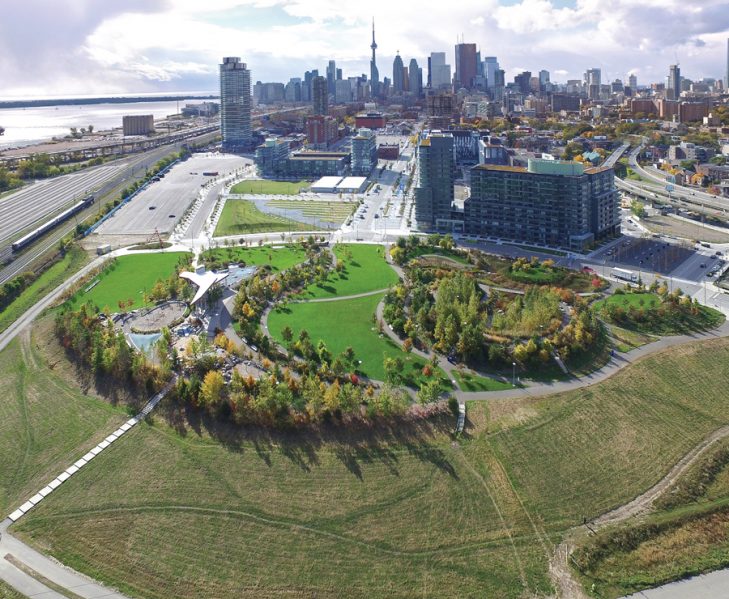 Corktown Common borders the Canary District, a mixed-use development that initially housed athletes during the 2015 Pan Am/ParaPan Am Games. The park incorporates a raised landform that protects the eastern part of downtown (including the Canary District) from flooding.