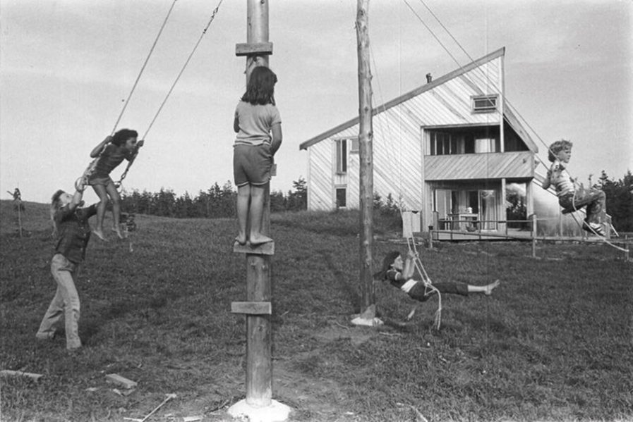 Children play in front of the wood-clad house in 1974. Photo: Nancy Willis