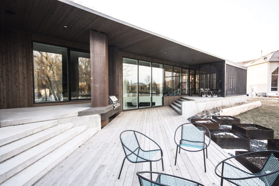 Floor-to-ceiling windows and a cascade of terraces open towards the backyard.