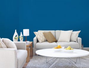 Pairing blue and white in a room with hardwood flooring delivers a coastal, beach-like ambiance. Pictured on the walls of this living area is Blazer Blue by Dulux Paints.