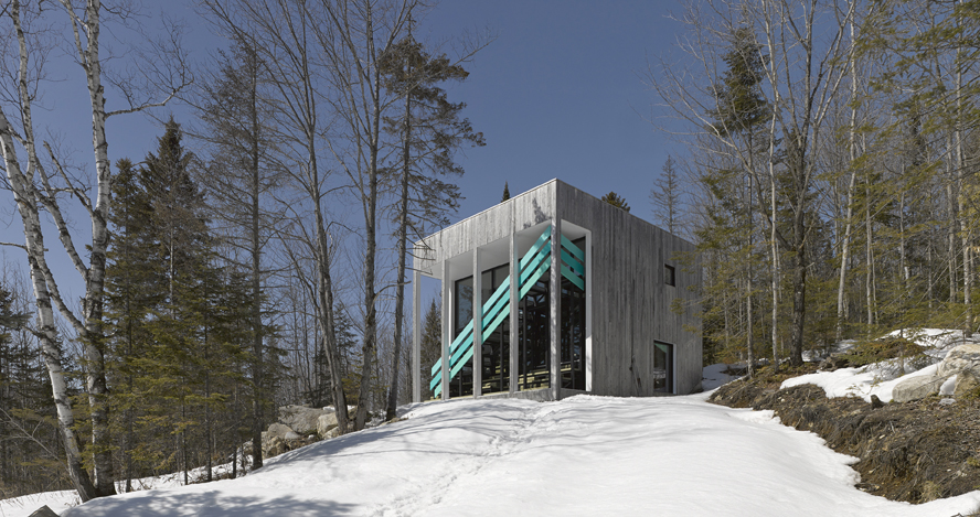 The cottage/studio is a basic cube fronted by a classical portico but disrupted and tied back to the romantic landscape by a three-dimensional turquoise chevron tucked behind simple classical columns. Photography by James Brittain Photography