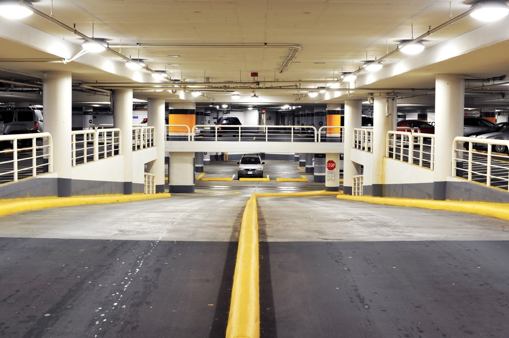 Metrotown Parkade Lighting Upgrade - “After” image of a parkade ramp with new light-emitting diode (LED) fixtures. Yellow safety features, stop signs, and pedestrians are now highly visible to drivers. Photo credit: Dmitri Eliasov