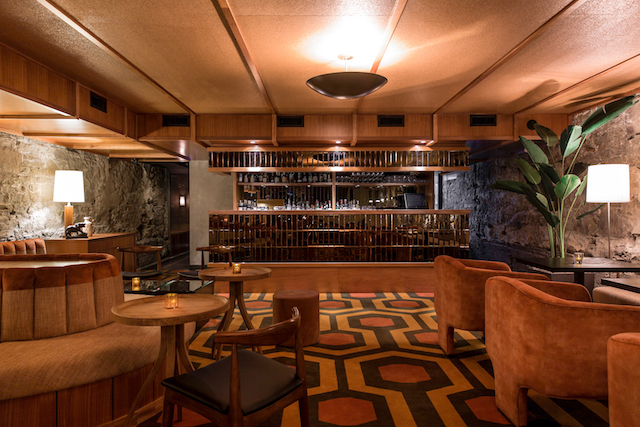A mix of a sophisticated ‘60’s lounge and your uncle’s eclectic basement, rich wood paneling, textured plaster, mixed metals and luxurious textiles create a distinctly residential feel in the Wednesday Room, by McKinley Burkart. Calgary