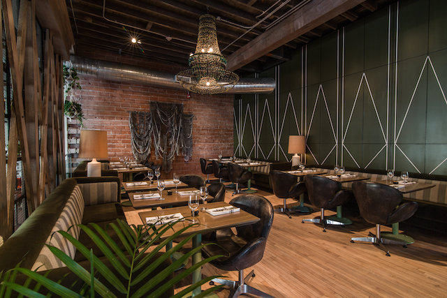 A clearly unpretentious tone of Bridgette, completed in the fall of 2016 by Frank Architecture, is conveyed through the use of vintage furniture oriented around a suspended wood-burning fireplace, exposed construction material and an unusually low green marble bar.