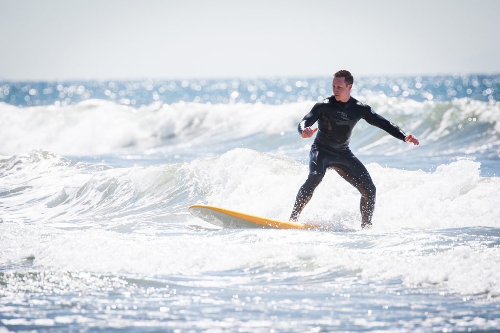 Man catches a wave at surf lessons in Santa Monica