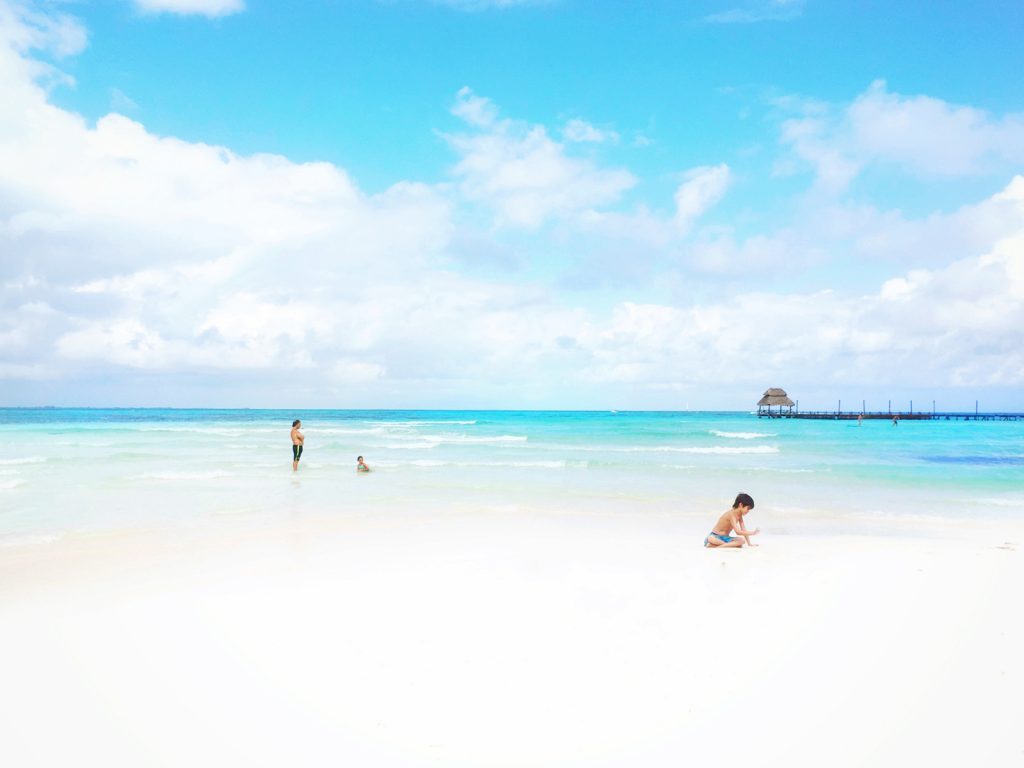 Children play in the white sand at Playa Norte on Mexico's Isla Mujeres.