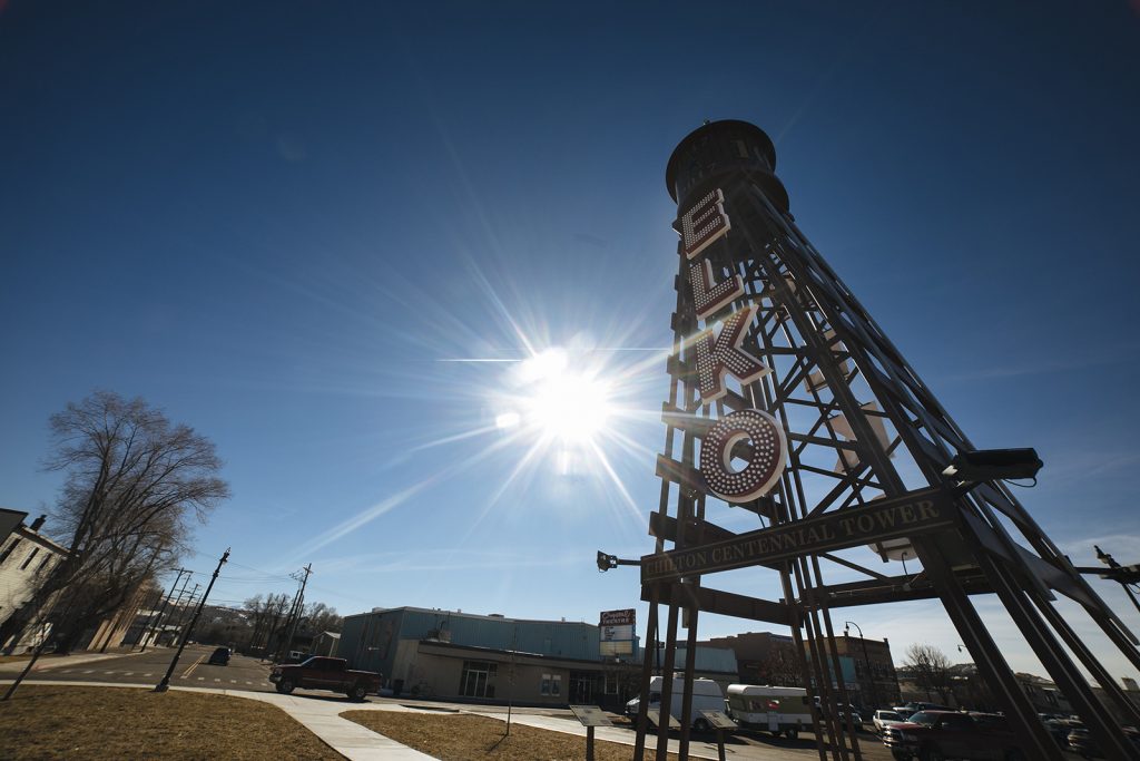 The sun shines behind the Elko Water Tower