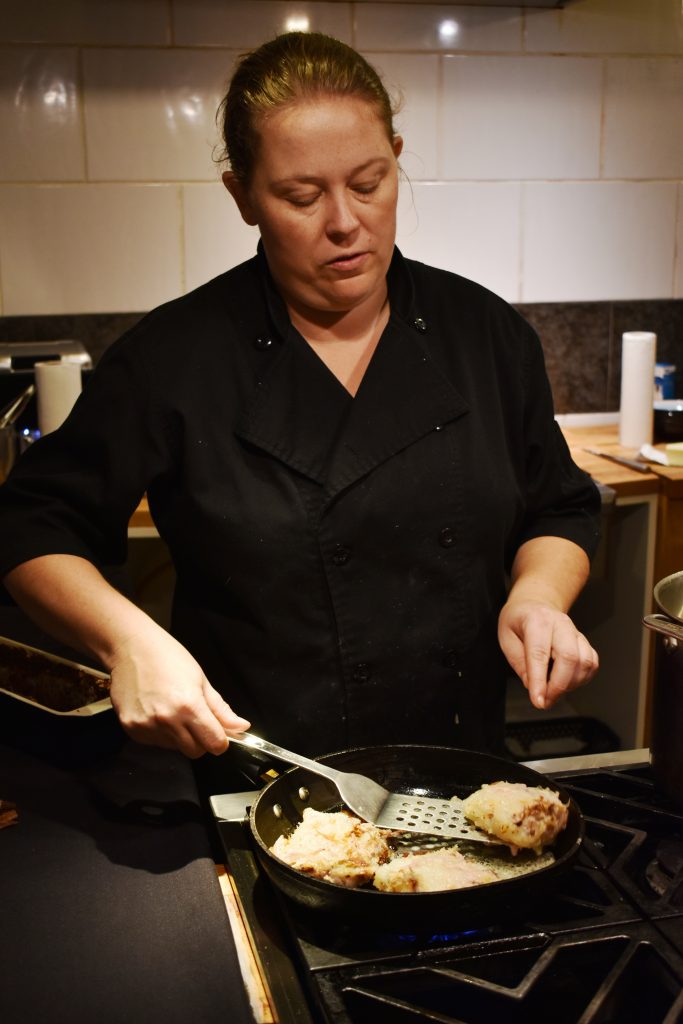 Kara Pinkney-Crowell flips a wedge of rappie pie in a cast iron pan