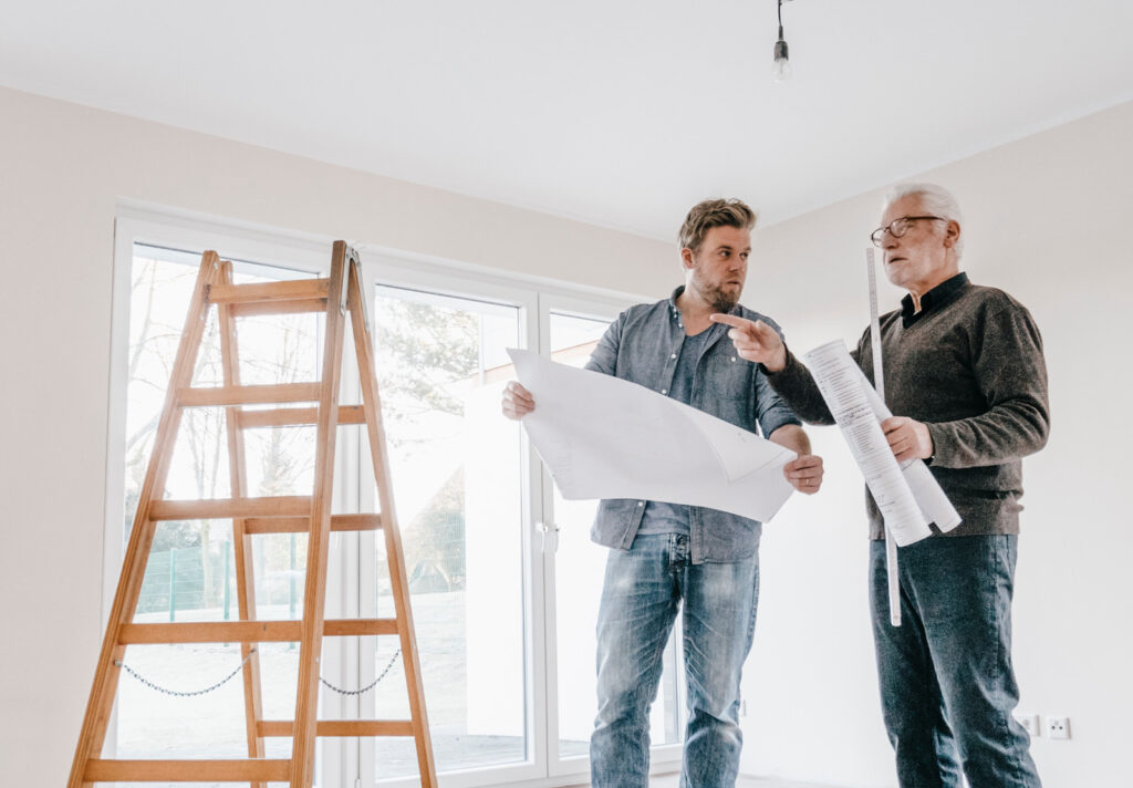 men with blueprints in home