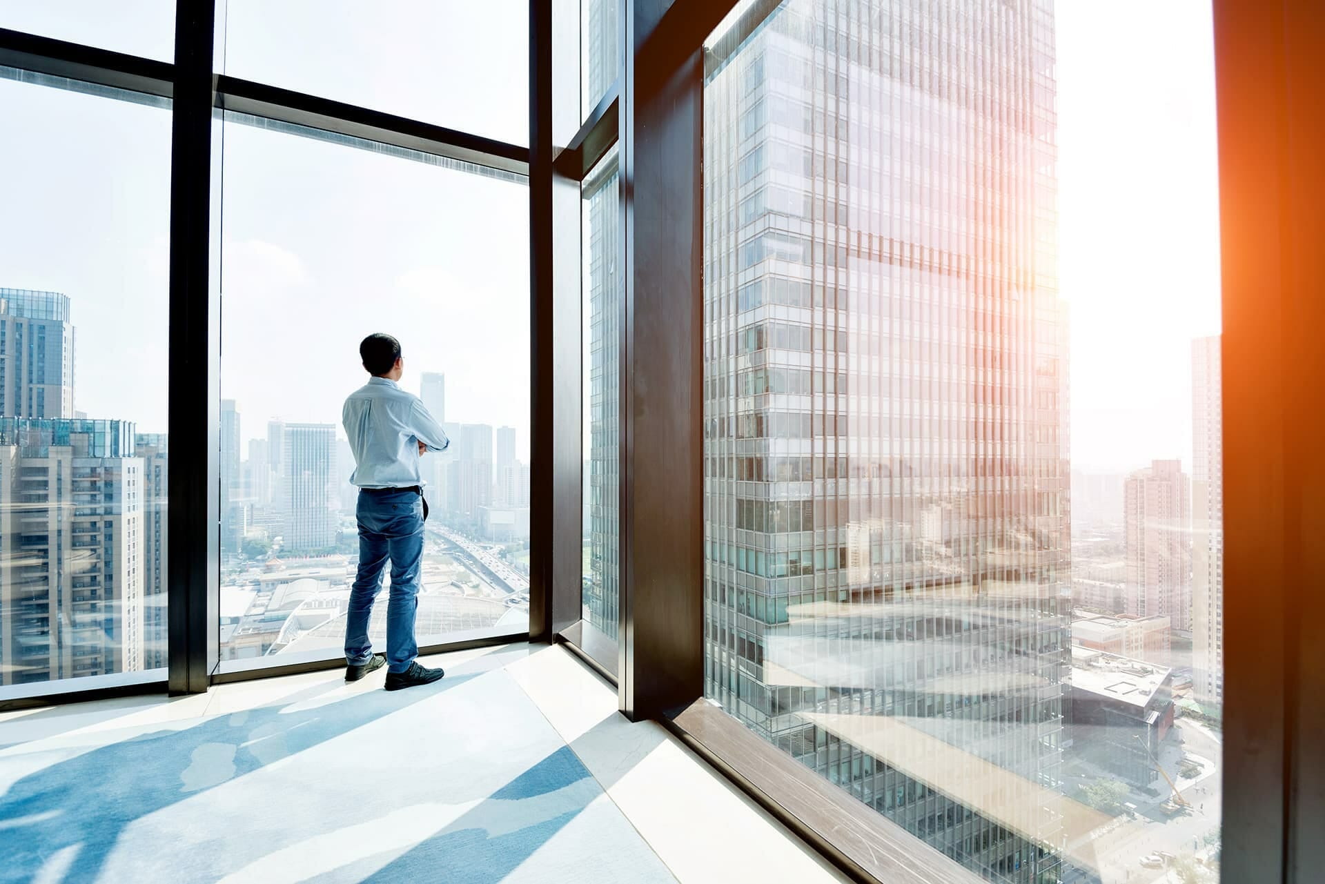 Man staring out a big window thinking about surety bond insurance