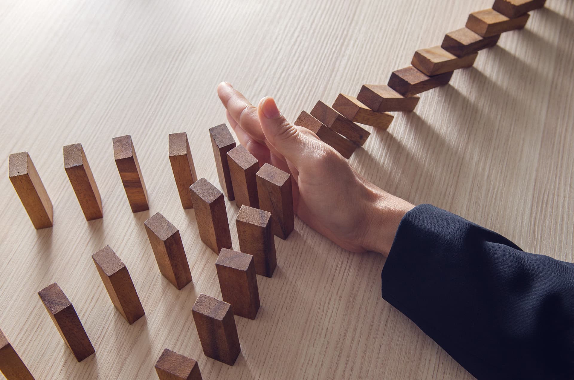 Business interruption insurance for person stopping dominos from falling