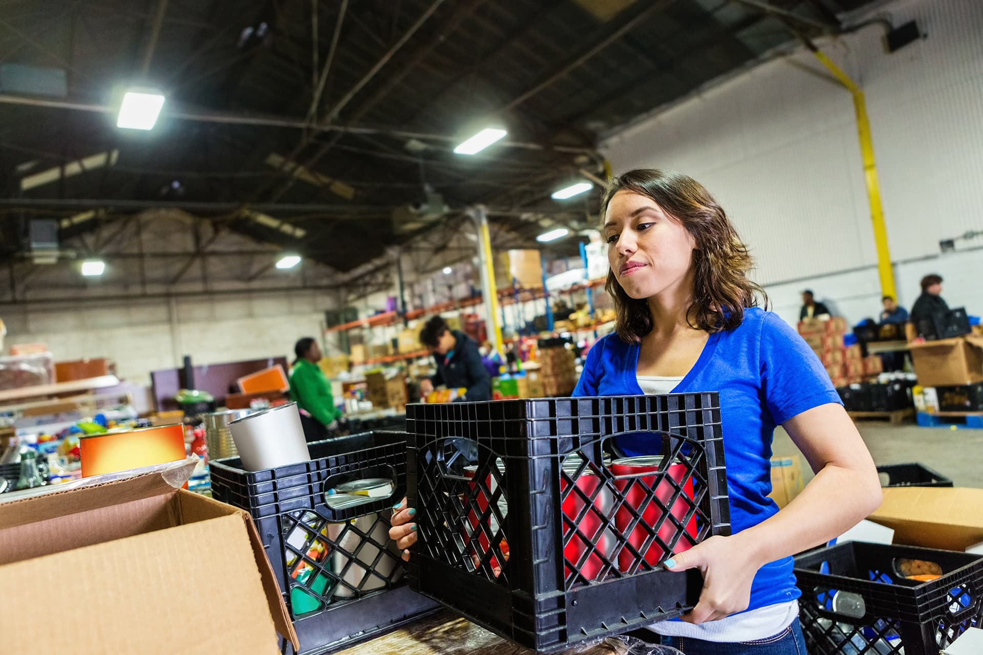 Non-profit insurance for woman carrying a crate of supplies in a warehouse