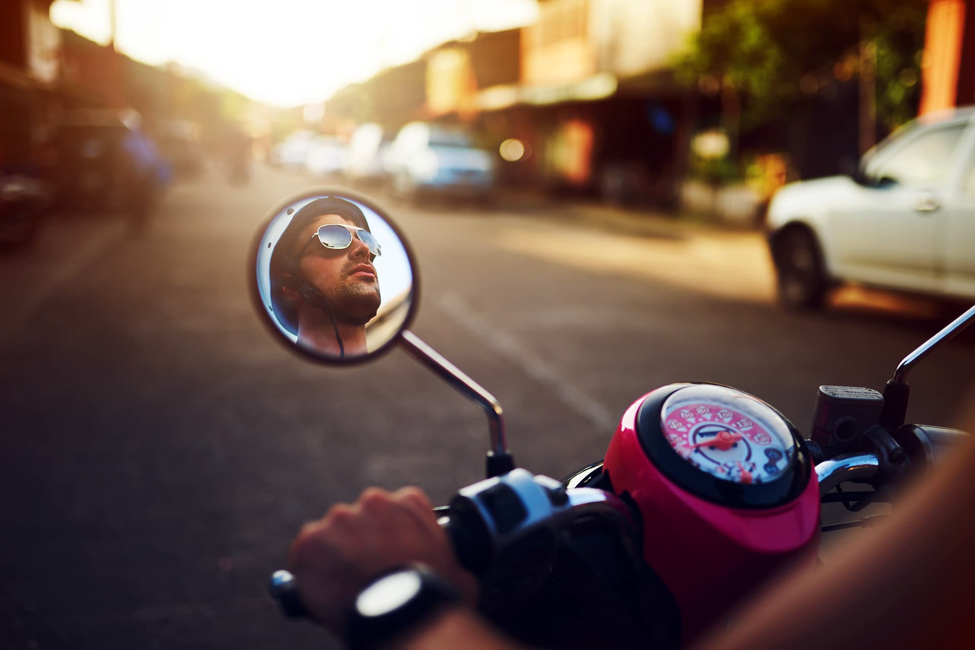 Man riding a motorcycle on a city street with motorcycle insurance