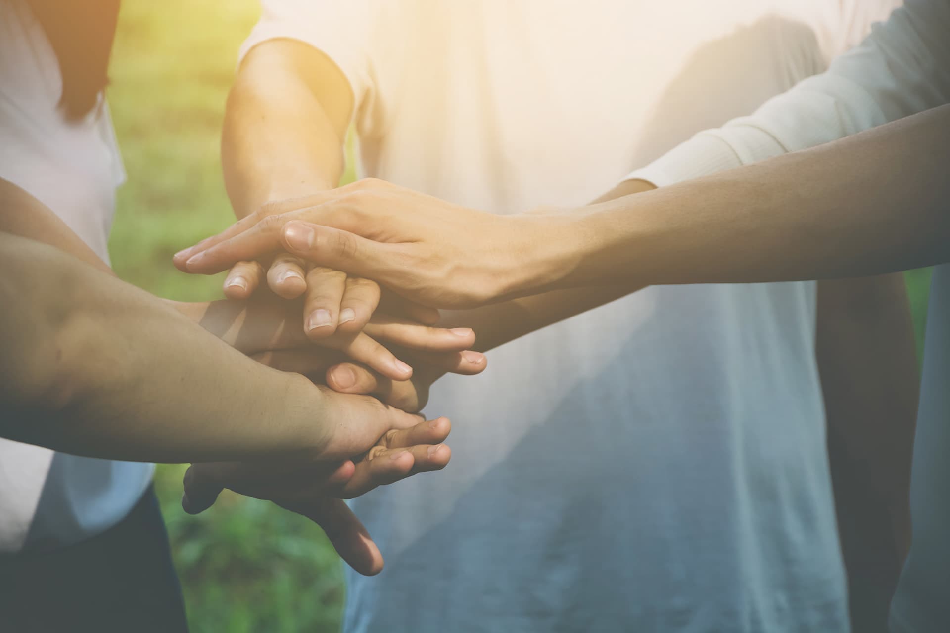Non-profit insurance for people piling hands together in a team huddle