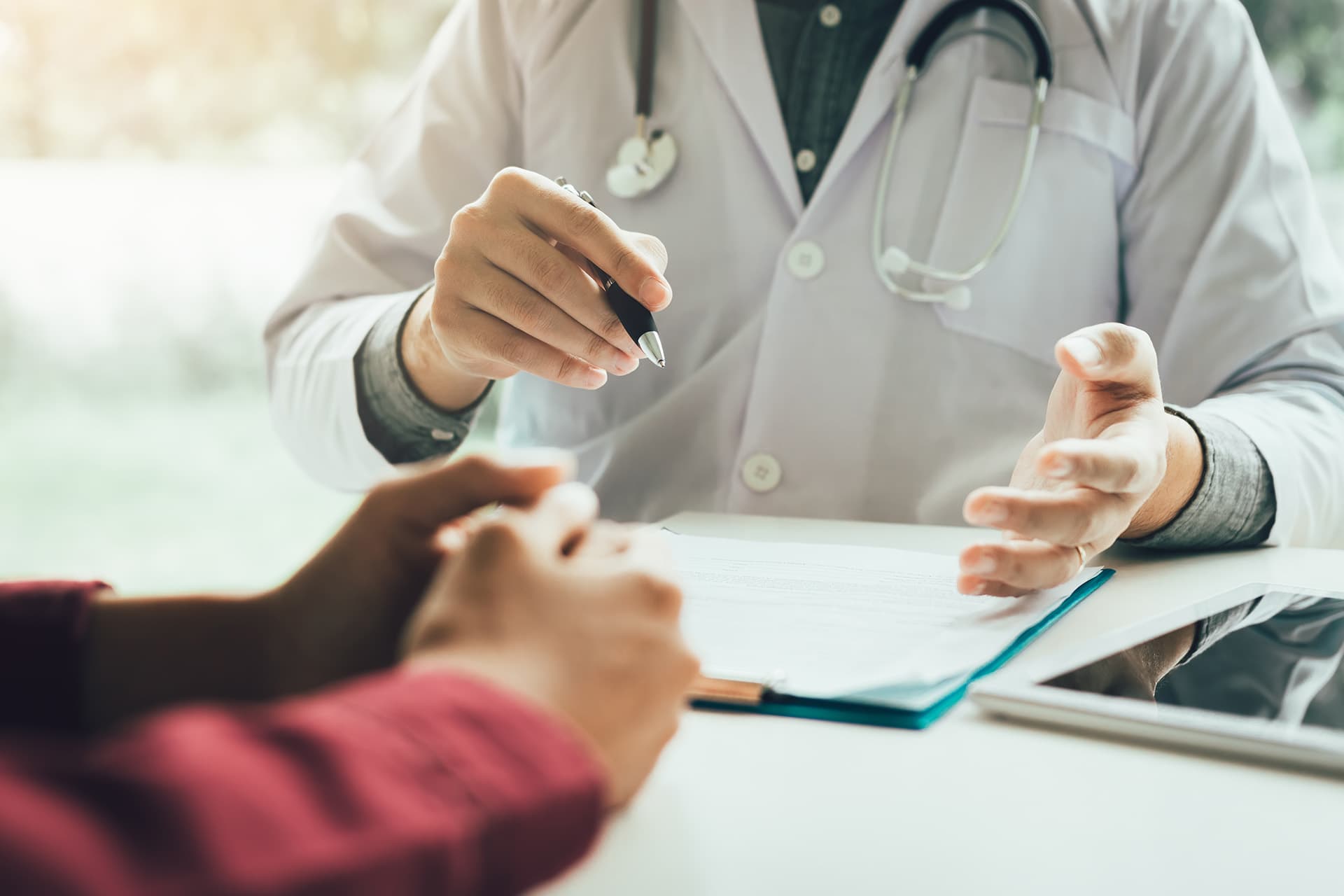 Doctor with medical insurance reviewing paperwork with patient