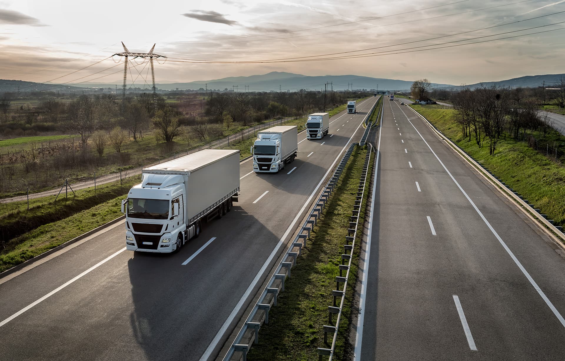 Four trucks driving down the highway with auto fleet insurance