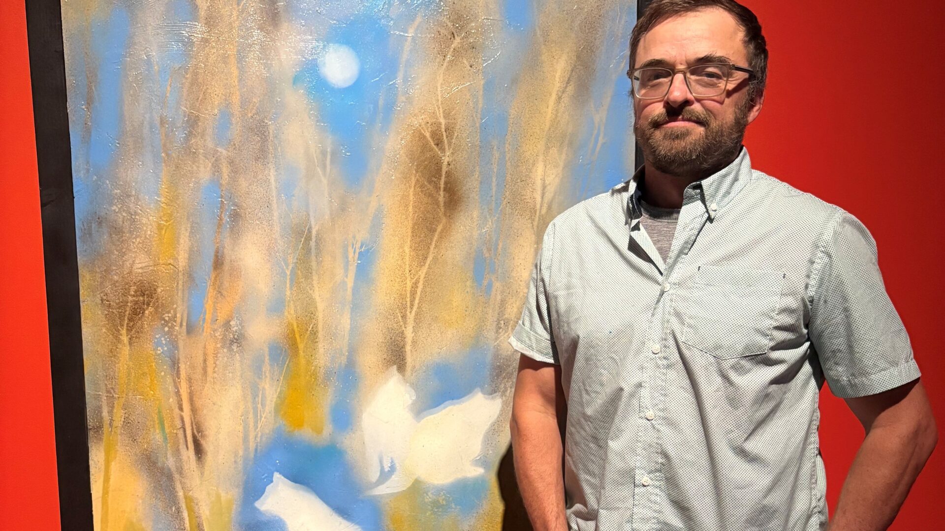 Jimmy Perron posant devant sa toile favorite de l’exposition. 
(Photo Médialo – Marie-Christine Gaudreau)
