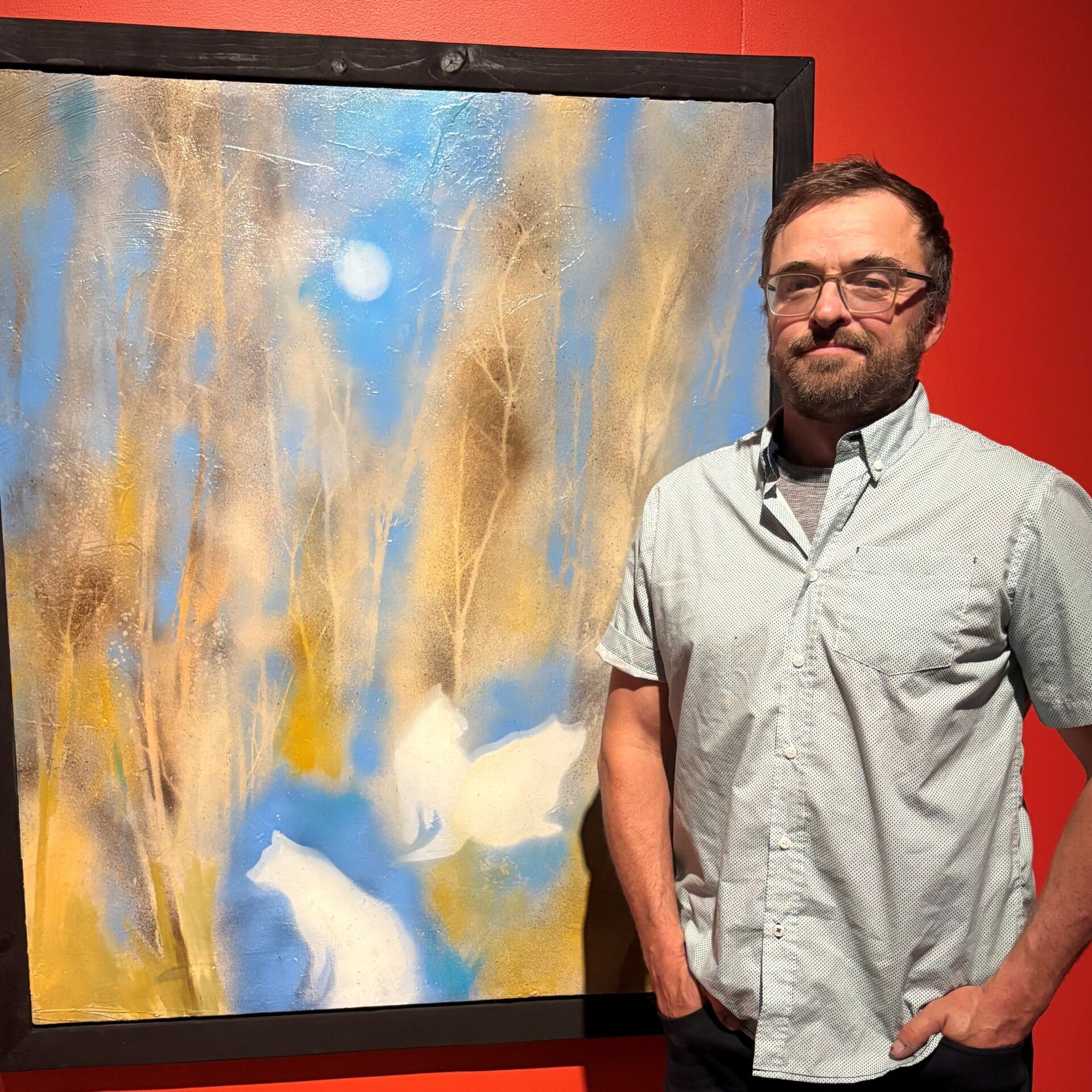 Jimmy Perron posant devant sa toile favorite de l’exposition. 
(Photo Médialo – Marie-Christine Gaudreau)
