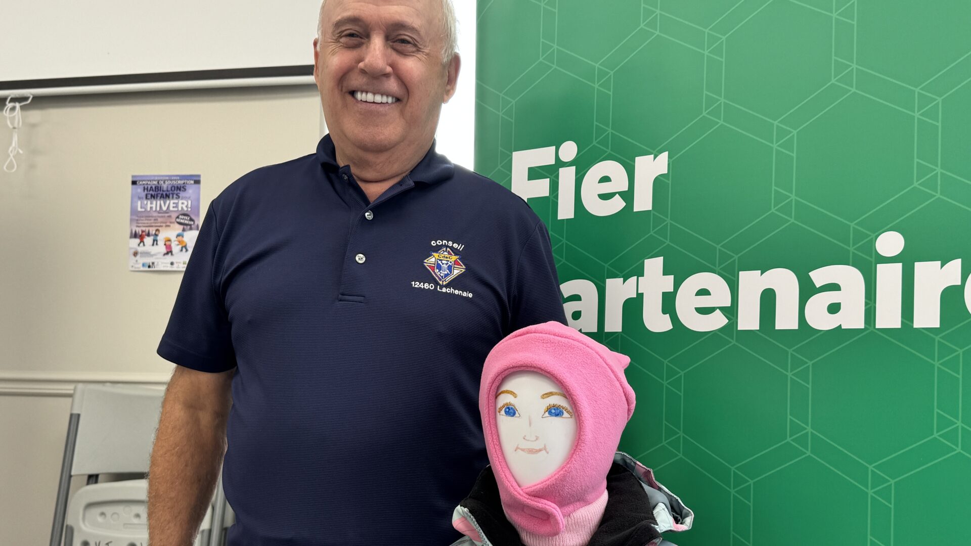 Richard Chaput pose avec un exemple de manteau donné aux enfants. Photo Médialo - Alex Proteau