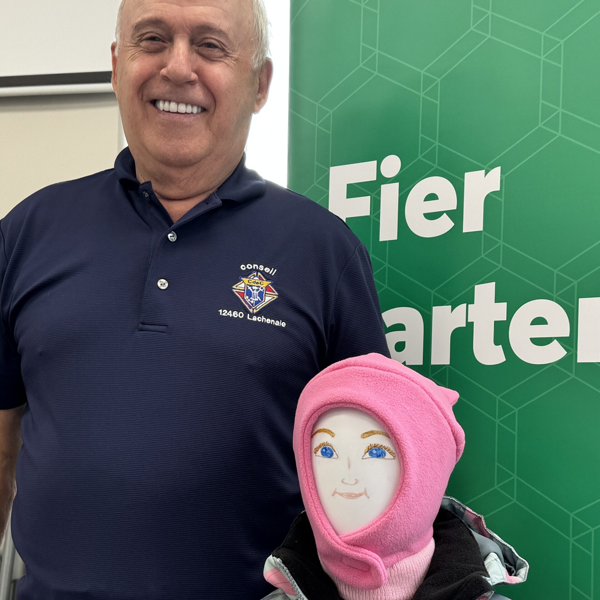 Richard Chaput pose avec un exemple de manteau donné aux enfants. Photo Médialo - Alex Proteau