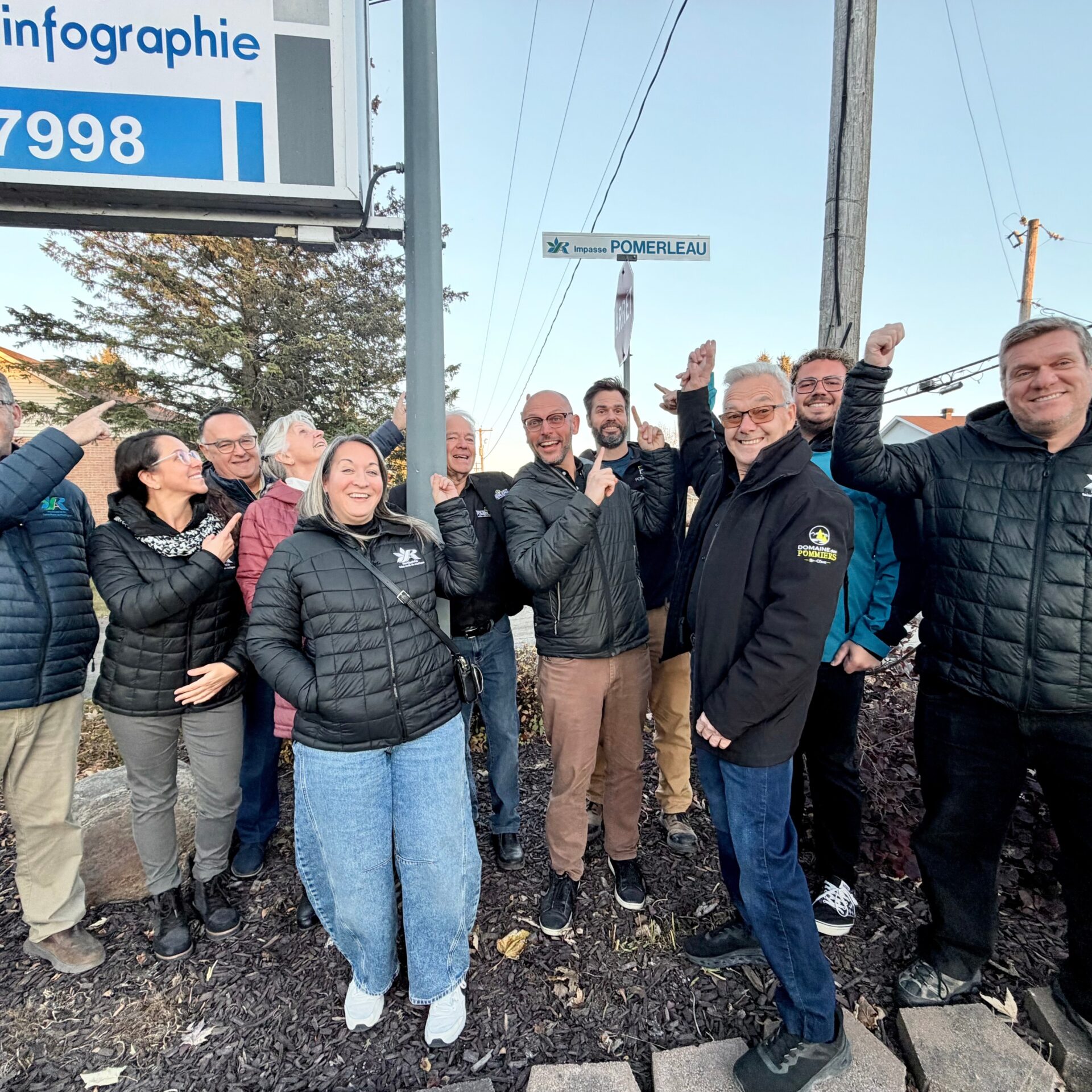 Des membres de la famille Pomerleau accompagnés des élus municipaux devant la nouvelle enseigne de l'impasse Pomerleau. (Photo gracieuseté)