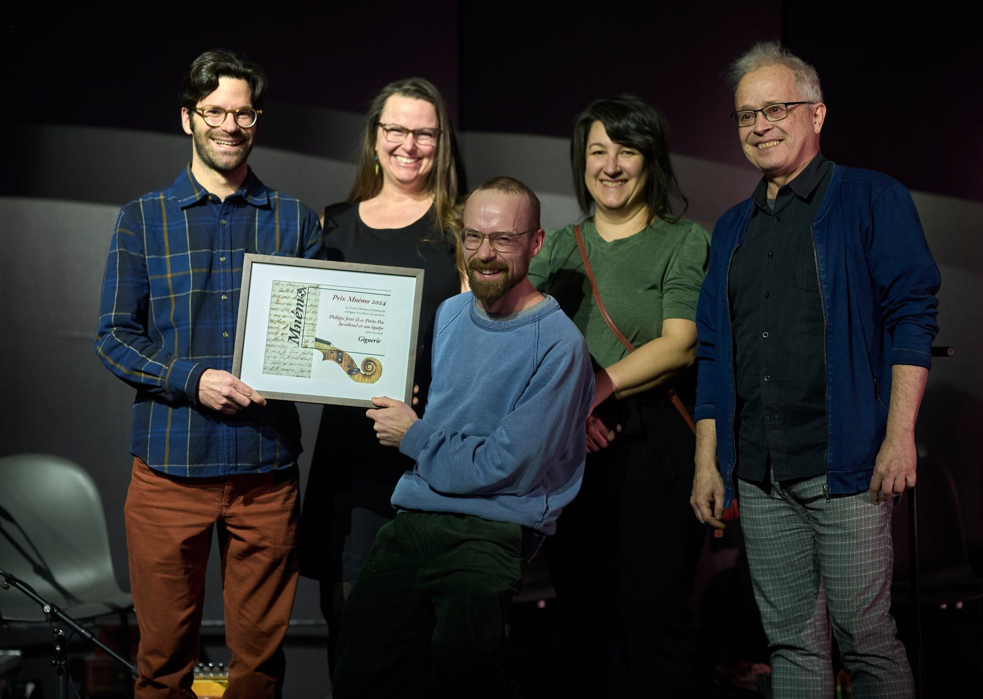 Philippe Jetté (président de Les Petits Pas Jacadiens) reçoit le Prix Mnémo pour le projet Giguerie, accompagné de Véronique Papillon, Mélody Clermont, et Pierre Chartrand, qui ont collaboré au projet (parmi tant d’autres). À l’avant, Antoine Turmine (président du Centre Mnémo) qui remet le Prix. (Photo gracieuseté – Guillaume Morin)