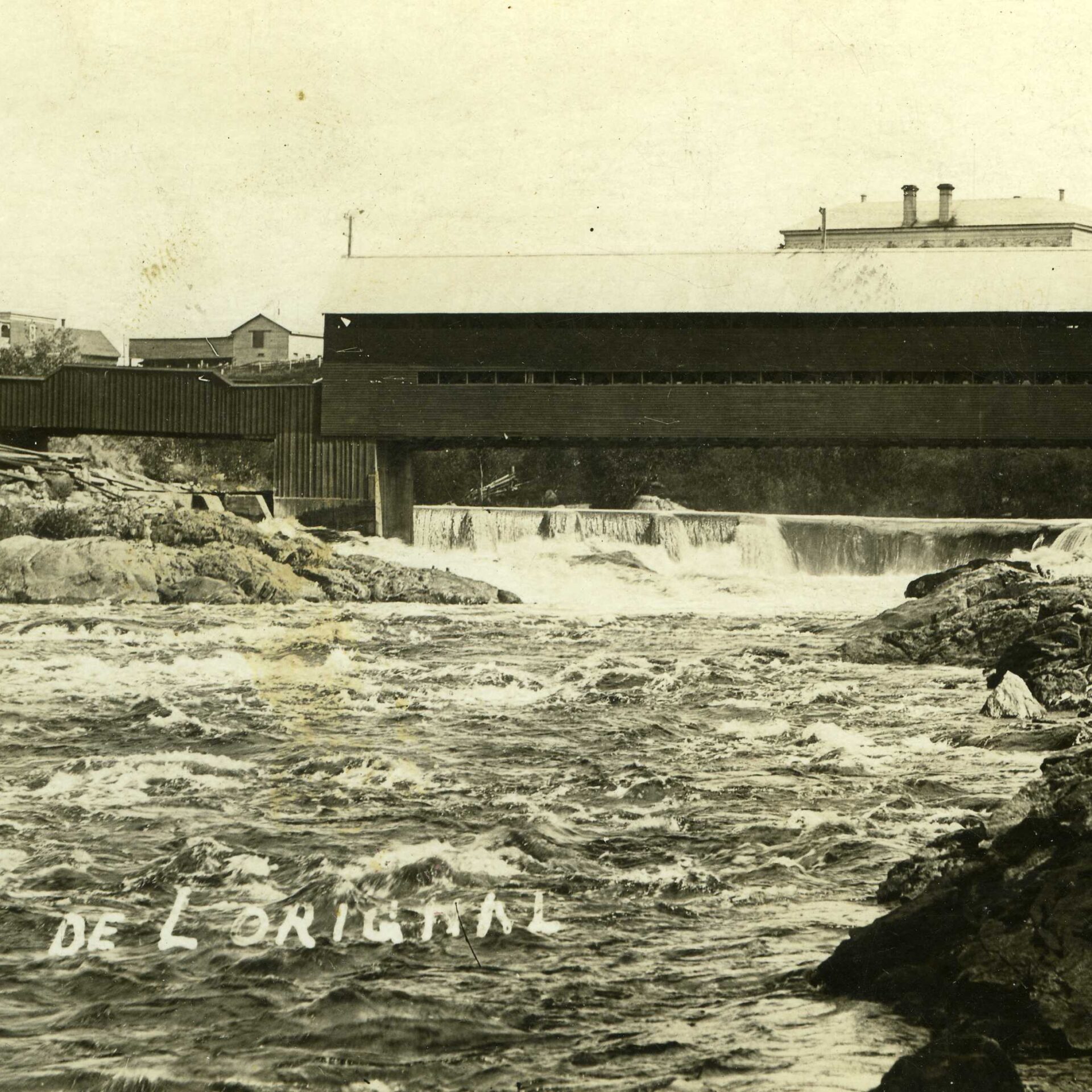 Vue sur la rivière du Lièvre et sur le pont Allard (aujourd'hui le pont Reid) à Mont-Laurier. Vers 1900.
Photo gracieuseté - Société d’histoire et de généalogie des Hautes-Laurentides
