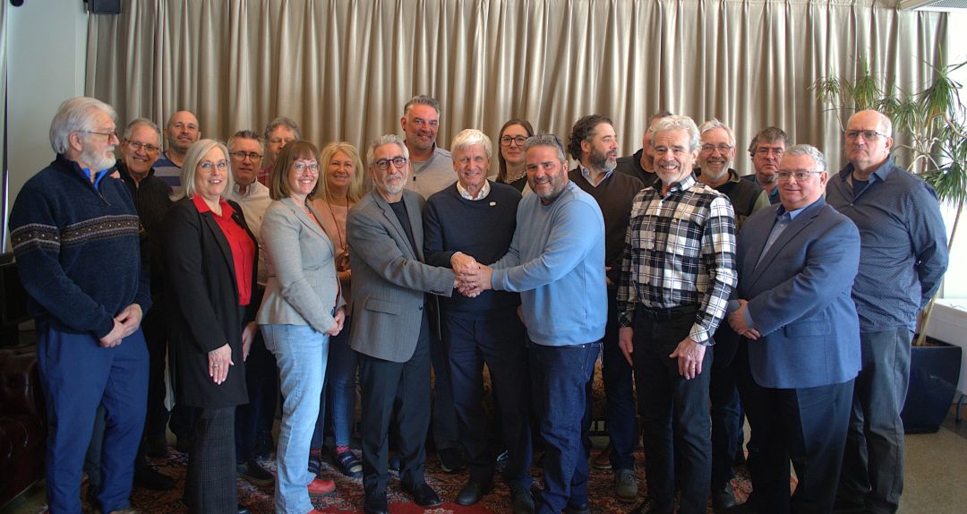 Au centre, Marc L’Heureux, préfet de la MRC des Laurentides, entouré à sa droite par Kimberly Meyer, préfète suppléante et présidente du comité en développement social, par François Savoie, directeur général de La Hutte et, à sa gauche par Frédéric Broué, maire de Sainte-Agathe-des-Monts, ville hôte du projet. Ils sont entourés par les mairesses et maires de la MRC des Laurentides qui ont financé l’achat du terrain. / Photo: MRC des Laurentides