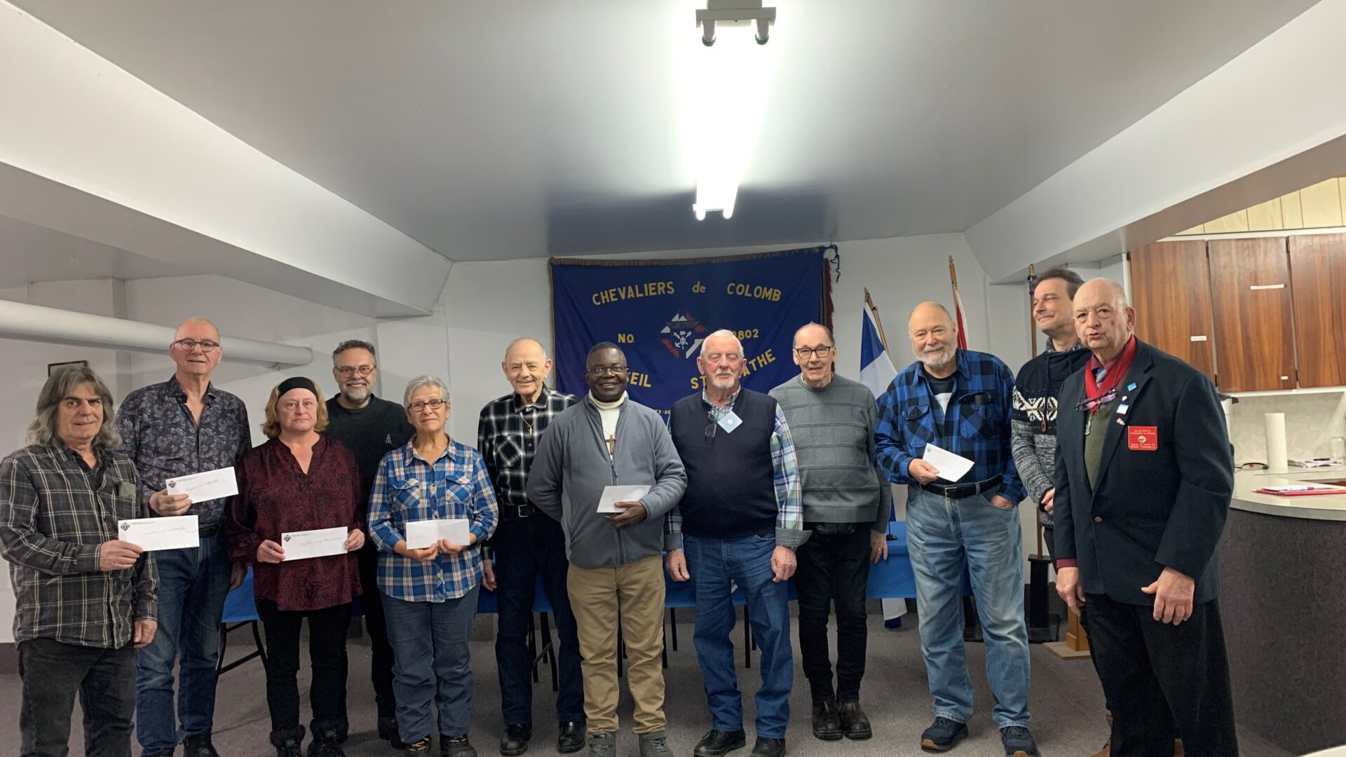 Au centre, l’abbé de la paroisse de Sainte-Agathe entouré des Chevaliers de Colomb de Sainte-Agathe et des représentants des banques alimentaires de la région. Photo Emmanuelle M. Verschaeve 