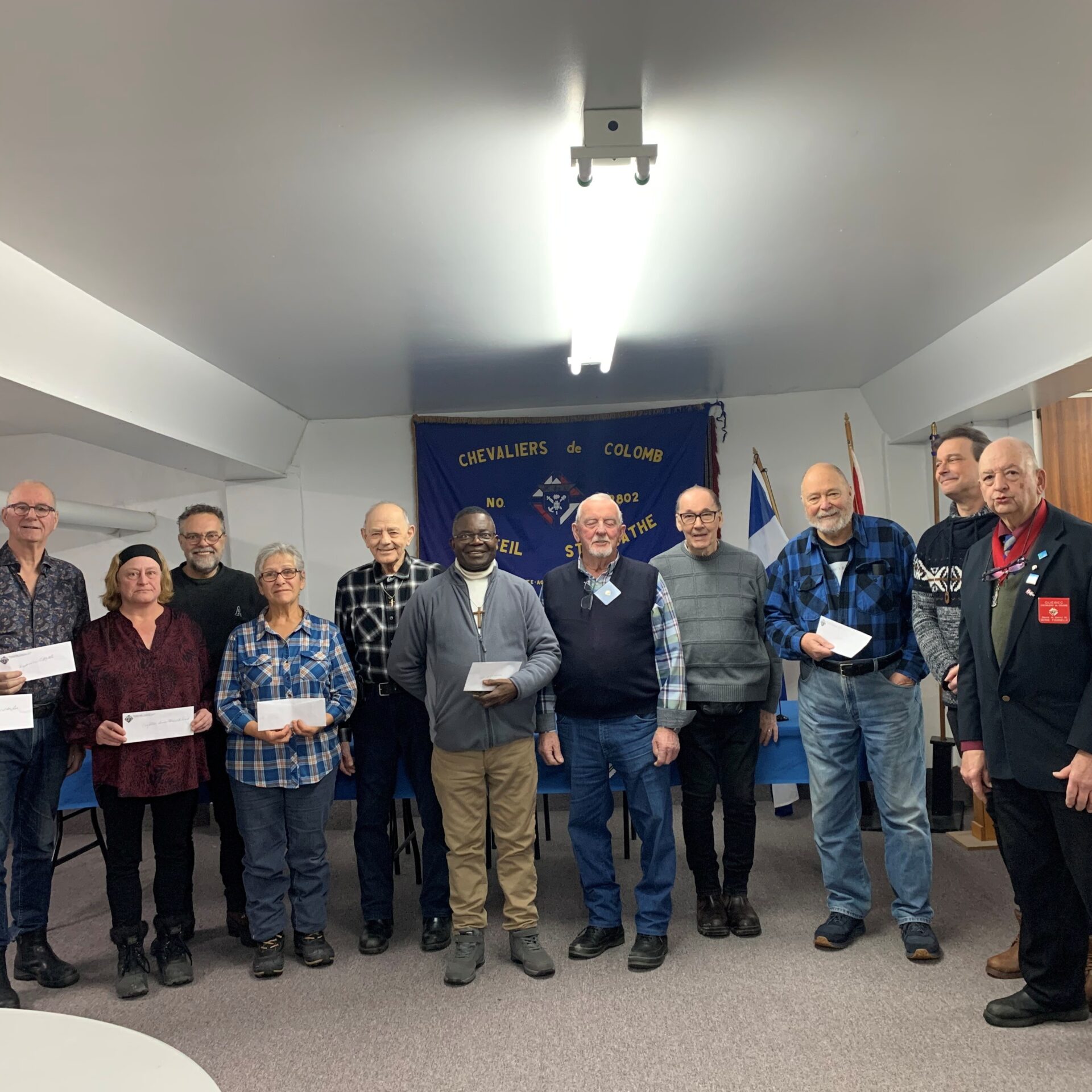 Au centre, l’abbé de la paroisse de Sainte-Agathe entouré des Chevaliers de Colomb de Sainte-Agathe et des représentants des banques alimentaires de la région. Photo Emmanuelle M. Verschaeve 