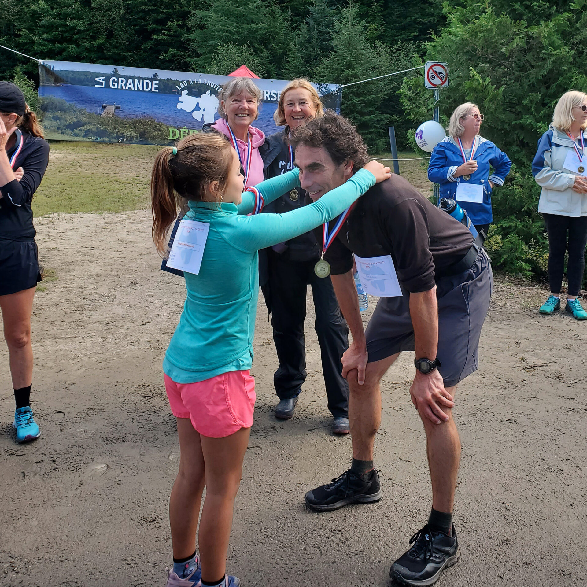 Remise de sa médaille au directeur de l’école La Relève, Éric Dubuc, qui a couru le 15 km sentier, par Alexandrine 7 ans qui a pris part à la course 1km sur route. Derrière, chandail rose, Gertrude St-Laurent, bénévole pour le Club des petits-déjeuners et Nicole Simard-Laurin, responsable du Club des petits-déjeuners de l’école La Relève.
(Photo gracieuseté)