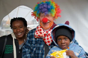 Une femme un homme déguisé en clown et un jeune enfant
