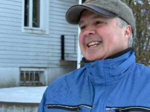 Un homme sourit à l'extérieur, l'hiver