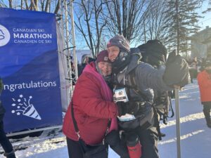 Une femme et un homme s'enlacent dehors au froid.